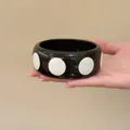 Elegante bracciale rigido in resina nera con grandi pois bianchi in un design di moda minimalista - Stile di Moda Semplice / Nero e Bianco