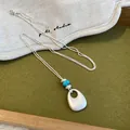 Détail d'un collier en argent mat avec perles turquoise et pendentif goutte d'eau. - 5# Style Rond / Argent