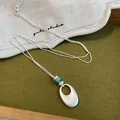 Vue détaillée du collier pendentif ovale en argent mat avec un accent de perle turquoise - 3# Style Ovale / Argent