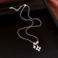 Primer plano detallado de un collar de plata con colgantes de flores incrustados de circón. - Estilo de Flor Hueca (HN13074) / Plateado