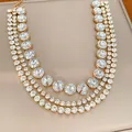 Close-up of a glamorous three-layer gold collar necklace with sparkling round crystals. - Gold