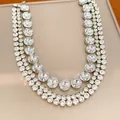 Close-up detail of a multi-layered rhinestone necklace with round crystal clusters. - Silver