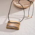 Detailansicht eines rechteckigen Harzanhängers im Vintage-Stil mit goldenem Akzent. - Halskette / Gold und Kaffee