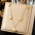 Detailed close-up of gold-plated ocean series necklace with shell and seahorse charms - Five Marine Elements Symmetrical Design (N4501)