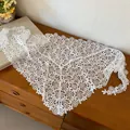 Detailed view of white floral crochet lace triangular scarf on a wooden surface - Flower Style / White