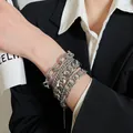Primo piano dettagliato che mostra un set di bracciali a catena argentati sovrapposti al polso - 5# Braccialetto / Set di 4 / Argento