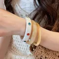 Dettaglio di bracciali rigidi in acrilico impilabili con strass e texture marmorea - Stile 29 / Set di 3 / Giallo, Bianco