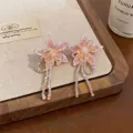 Close-up view of elegant pink fabric flower earrings with iridescent beaded tassels detail - Stud Earrings (1 Pair) / Pink