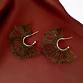 Detalle de pendientes artesanales de alambre tejido en forma de abanico verde y oro - Verde