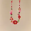 Gros plan d'un collier de perles fait main avec des breloques florales colorées. - Rouge Vert et Rose