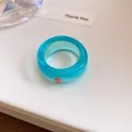 Gedetailleerde opname van een cyaan harsring met een fonkelende roze strass-steen - Blauw