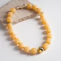 Detailed shot of marbled acrylic beads and shiny gold sphere on retro chunky necklace - Necklace / Gold-Beige