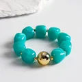 Detail of turquoise marbled acrylic bead bracelet with large polished gold sphere. - Bracelet / Gold-Blue