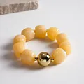 Detailed macro view of marbled acrylic beads with a large gold metal bead accent - Bracelet / Gold-Beige