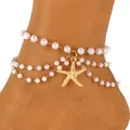 Detail van gelaagde enkelband met imitatieparels en een goudkleurige zeester hanger - Parel Drielaagse Zeester Stijl (7635) / Goud/Wit