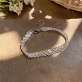 Close-up of a delicate iridescent beaded bracelet with a lobster clasp on a wooden surface - Bracelet / Colorful