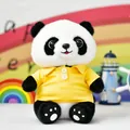 Schattige reuzenpanda knuffel met een geel poloshirt in een kleurrijke omgeving - Panda in geel poloshirt
