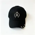 Dettaglio di un cappello da baseball nero con ciondolo a stella e anelli metallici sulla visiera - Stella A Cinque Punte E Mezzo Anello Nero