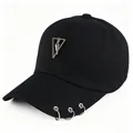 Dettaglio di cappellino da baseball nero con anelli metallici sulla visiera e ciondolo a triangolo - Nero Con Etichetta a Triangolo