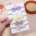 Hand holding a card with five waffle knit bow headbands for infants in pastel colors - 5D Combination