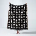 Full view of a high-quality woven skull pattern blanket featuring decorative fringe tassels - Black Skull Jacquard / 130x160cm