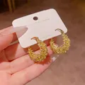 Elegante goldene Creolen mit einer strukturierten Oberfläche auf Schmuckkarte - Gehämmerte Creolen mit Körnungsstruktur (E7137) / Gold