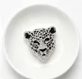 Gros plan détaillé d'une broche tête de léopard étincelante avec strass et émail noir - Argent