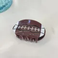 Cute football-shaped acetate hair claw clip in brown for sports fans styling - Rugby Ball