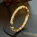 Detailed macro view of a gold-plated bangle set with sparkling cubic zirconia stones - Gold-plated Bracelet (set With Diamonds/zircon)
