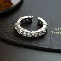 Close-up of silver-plated ring featuring CZ stones and crossing X motifs - Silver - Ring (diamond-set/open)