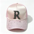 Vista dettagliata del berretto in raso rosa con lettera R di strass e tesa di paillettes - Rosa / Taglia Adulto Circonferenza Del Cappuccio Regolabile 58 Cm