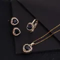 Detailansicht eines eleganten vergoldeten Schmucksets mit herzförmigen schwarzen Steinen - L