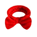 Fascia per capelli in flanella rossa con fiocco per lavaggio viso trucco e skincare - Una Fascia Per Capelli Con Fiocco Rosso Acceso
