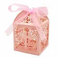 Pink laser-cut candy box with cross and vine pattern, tied with a matching ribbon. - Hollow Cross (JGH025) / Pink