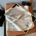 Close-up of elegant silk square scarf with horse pattern on a brown leather chair - Large Square / Houndstooth Horse Beige