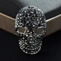 Gros plan d'une broche tête de mort argentée ornée de strass noirs pour un style punk - Style Strass Noir / Gris foncé