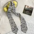 Detailed view of a black and white cow print skinny silk scarf on white fabric - Long Scarf Ribbon / Black White Cow Print