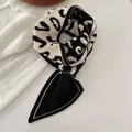 Nahaufnahme eines Strickschals mit markanten schwarz-weißen Buchstabenmustern - Schwarz Weiß Buchstabengestrick
