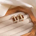 Brown crystal football stud earrings in gold finish with white enamel detailing - Rhinestone Football Stud Earrings (E8328)