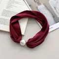 Nahaufnahme eines weinroten Satin-Stirnbands mit einer großen eleganten Perle - Weinrot Satin Perle