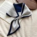 Detail eines eleganten blau-silbernen Satinschals mit einer funkelnden Strassschnalle - Blau Silber Strassschnalle