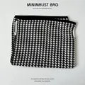 Detailansicht eines schwarz-weißen Hahnentritt-Strickmusters auf einem weichen Stoff. - Schwarz Weiß Hahnentritt Tasche