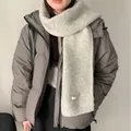 Detail eines gemütlichen hellgrauen Strickschals aus Wollmischung mit einer grauen Daunenjacke - Hellgraue Wollmischung