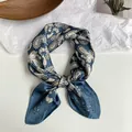 Detailansicht eines blauen Seidenschals mit elegantem Paisley-Muster und Knotendetail - Marineblaues Paisley