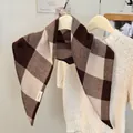 Weicher braun-beige karierter quadratischer Schal, elegant auf einem Kleiderbügel drapiert - Brauner Plaid