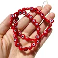 Gros plan de perles en verre œil grec rouges et plates pour la création de bijoux DIY - Rouge