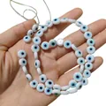 Vue détaillée de perles en verre œil de protection blanches tenues pour bijoux DIY - 6mm Environ 64 Pièces / Blanc