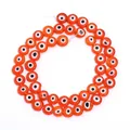 Detailed close-up of translucent orange evil eye glass beads for DIY jewelry making accessories - Orange Red