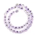 Close-up of purple flat round evil eye glass beads for DIY jewelry making - Purple