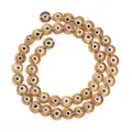 High quality detail shot of amber flat round evil eye lampwork beads for necklace DIY projects - Earthy Yellow